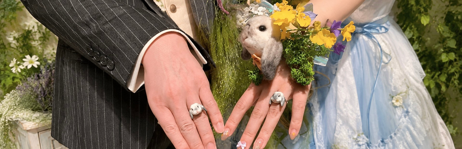 A close-up of a bride and groom showcasing custom pet portrait wedding rings alongside their pet chinchilla.