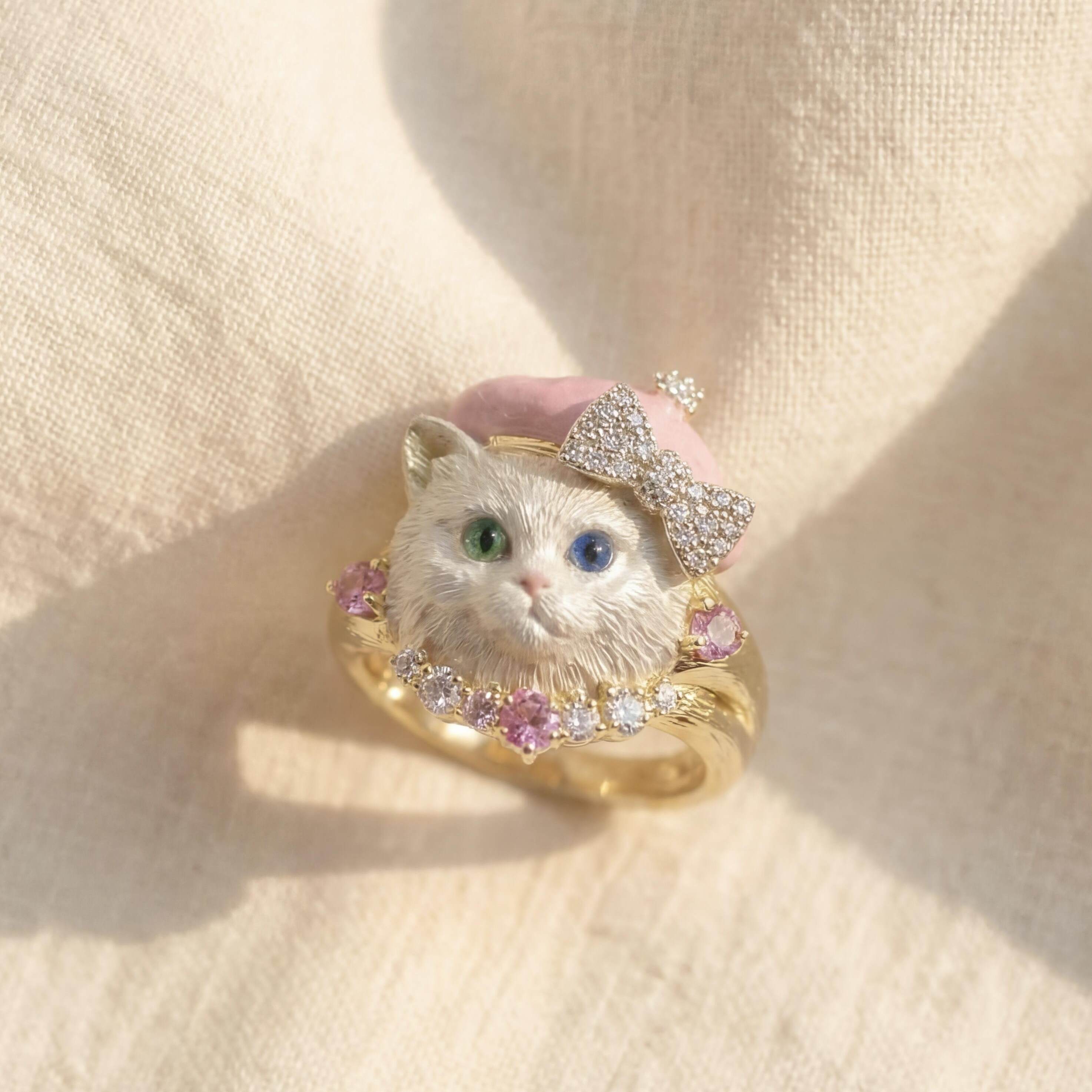 Ring with a cat design and gemstones on a beige fabric background