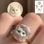 Cat-shaped ring with a close-up of a white cat's face and additional rings in the corner.