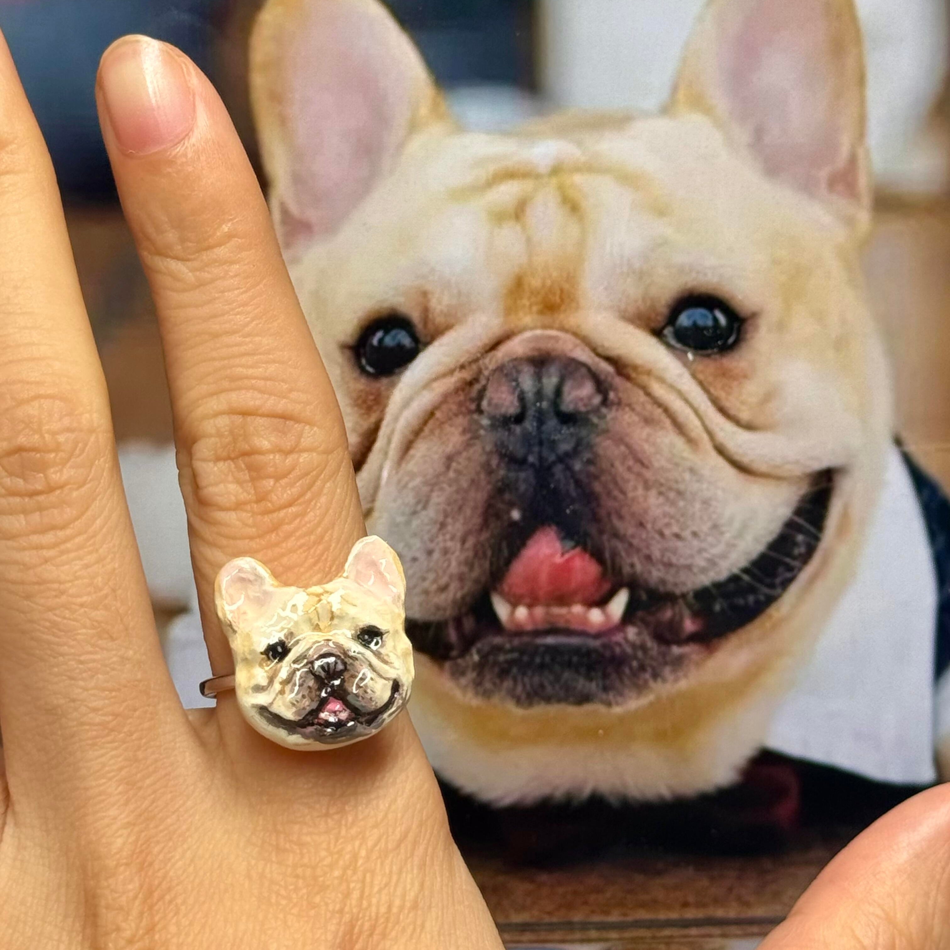 A real green parakeet next to a bespoke 3D pet portrait ring, custom hand-sculpted to perfectly replicate the bird as a luxury exotic pet jewelry keepsake.