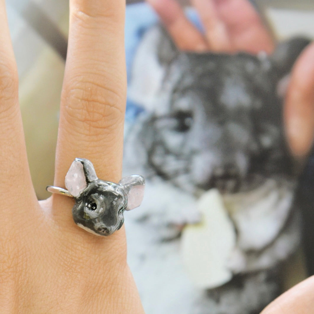 A custom hand-sculpted 3D chinchilla portrait ring worn on a finger, beautifully replicating a real grey chinchilla as a luxury exotic pet jewelry keepsake.