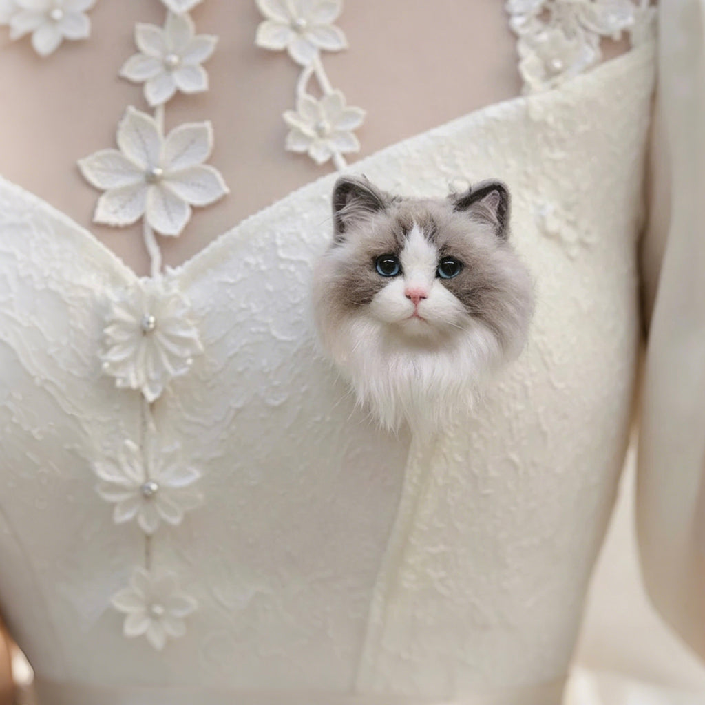 Cat sitting on a white wedding dress with floral embroidery