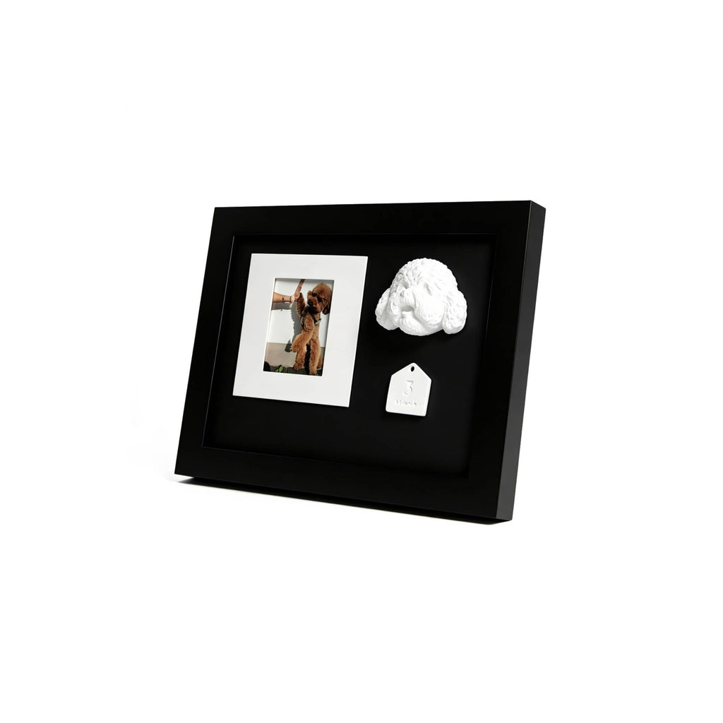 Black photo frame with a white cloud-shaped object and a tag on a white background
