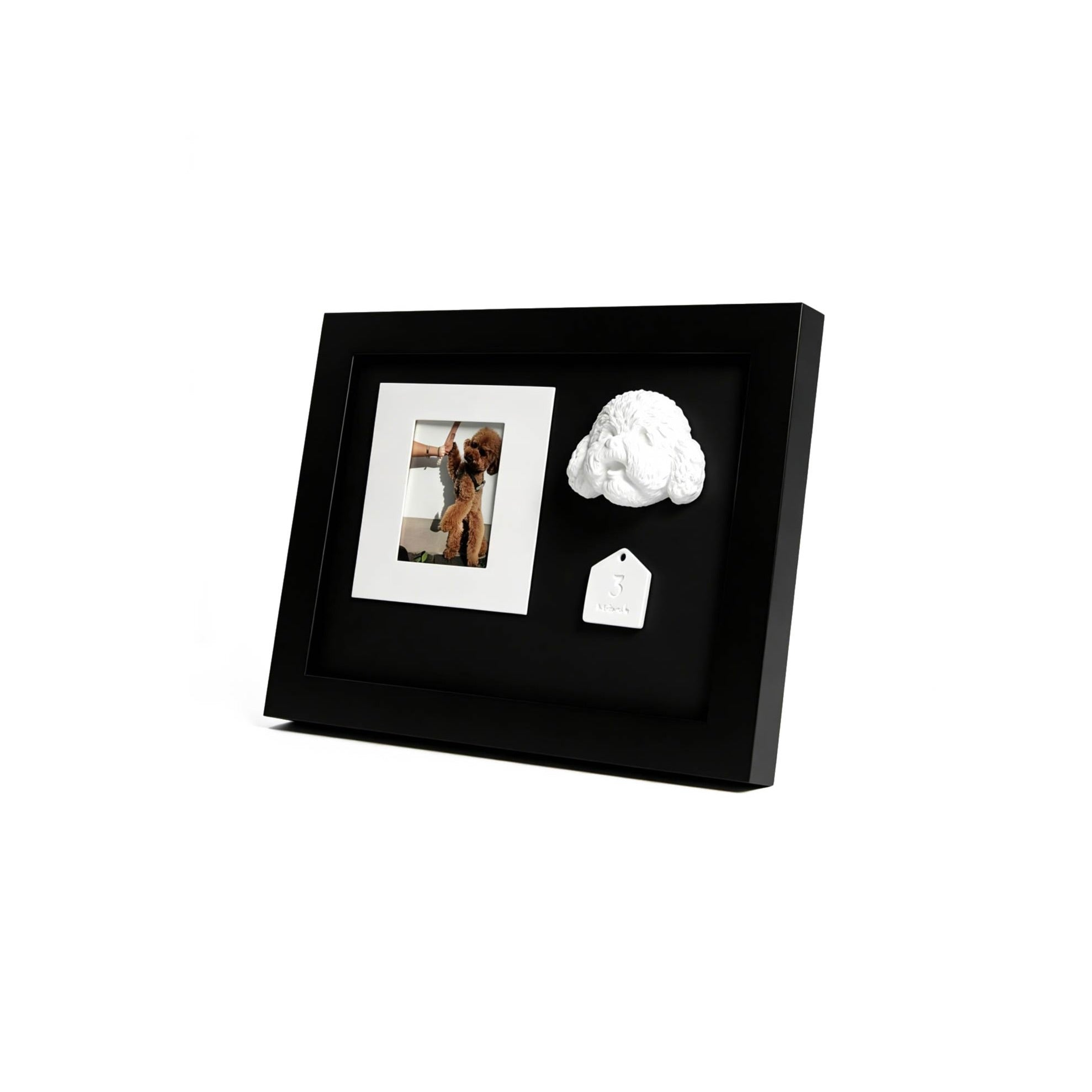 Black photo frame with a white cloud-shaped object and a tag on a white background