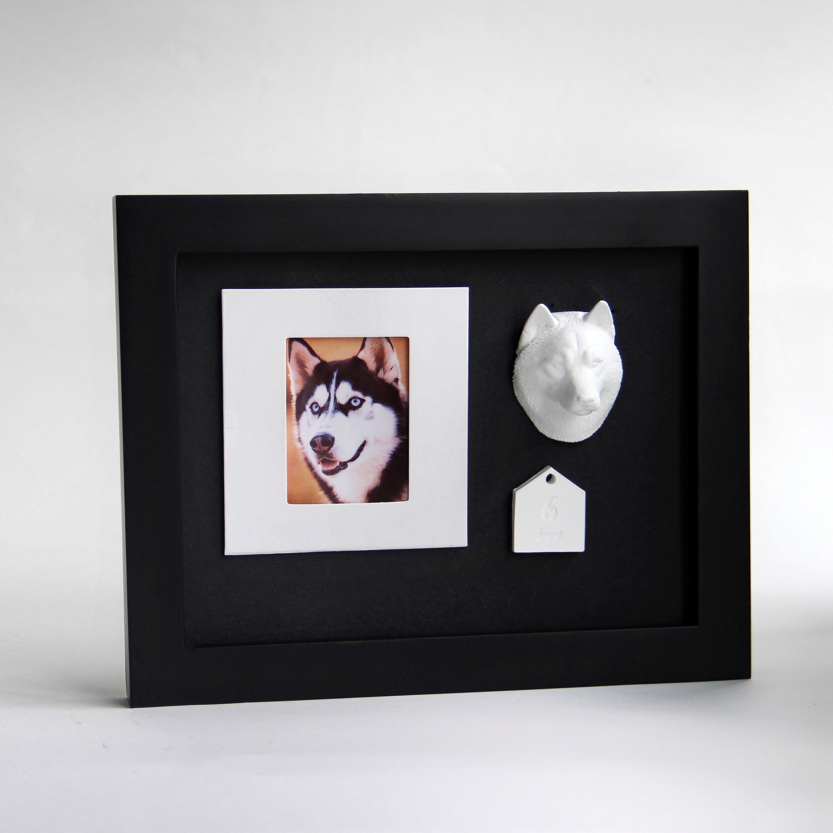 Framed artwork with a dog portrait and decorative dog head and bone on a white background