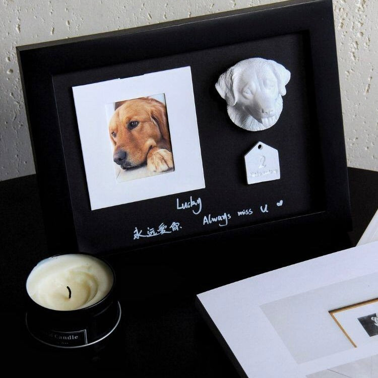 Memorial frame with a photo of a dog, a sculpture, and text on a black background.
