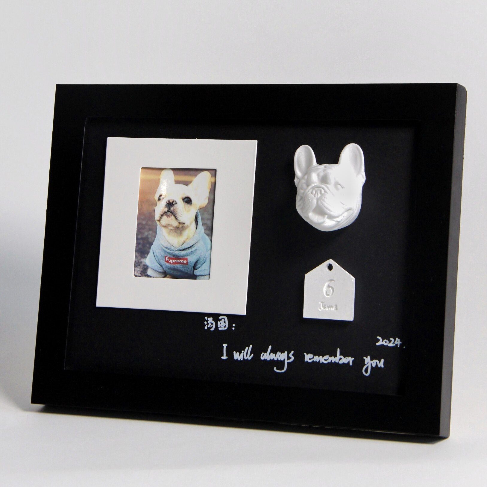 Black framed with a photo of a dog, a dog tag, and text on a white background