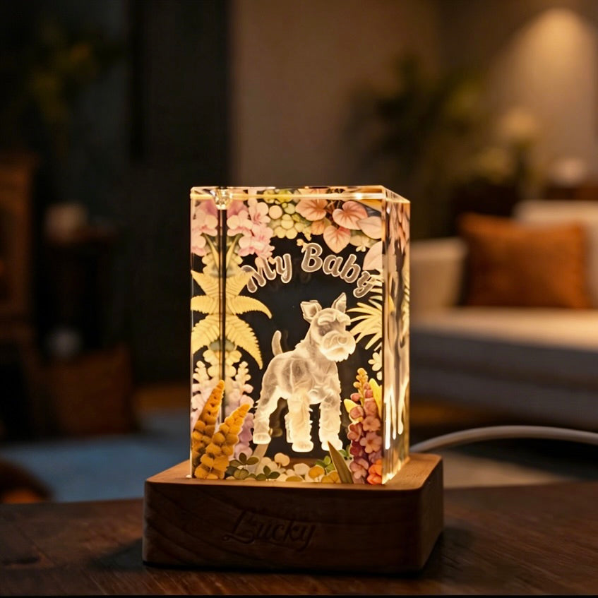 3D laser-etched pet crystal memorial lamp glowing with a soothing warm white light in a dark room setting.