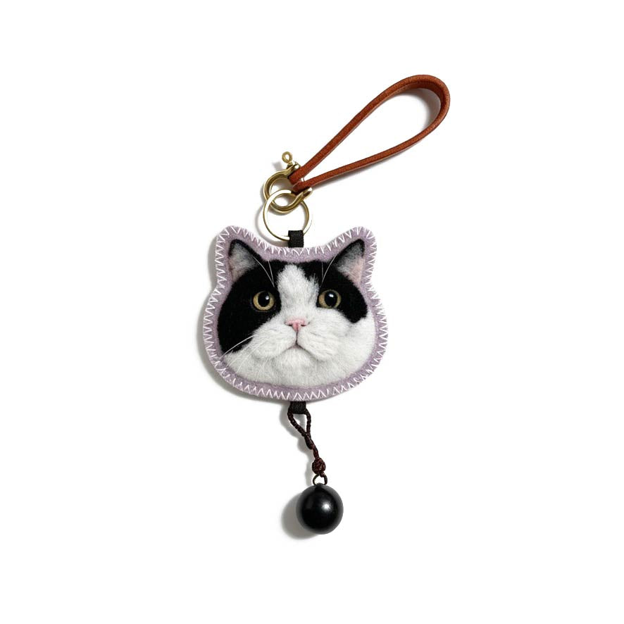 Cat-shaped keychain with a leather strap on a white background