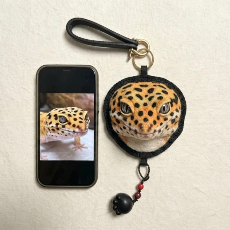 Phone case with leopard design and matching keychain on a beige background