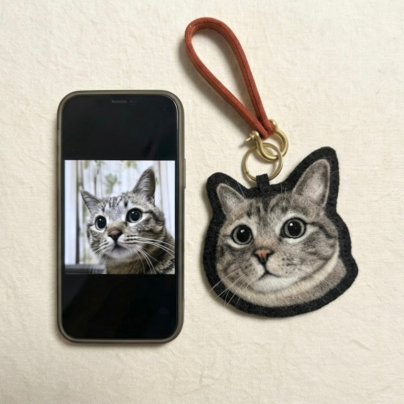 Phone case with cat design and matching keychain on a beige background