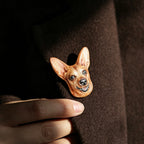 Dog-shaped brooch on a brown coat with a hand adjusting it.