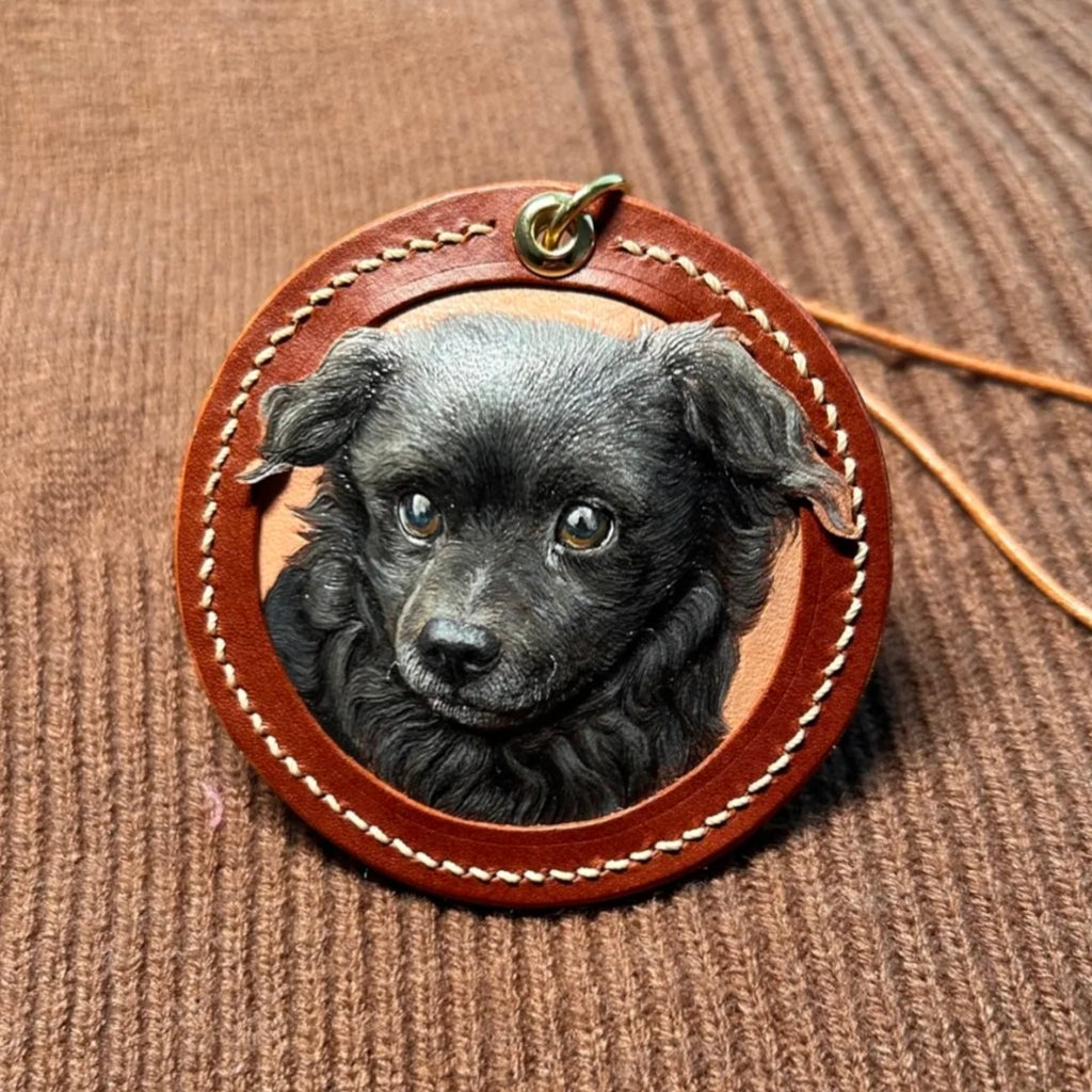 Round leather pendant with a black puppy's face on a brown textured background