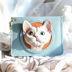 Light blue cardholder with a cat's face design on a white fabric background