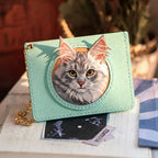 Green wallet with a cat design on a surface