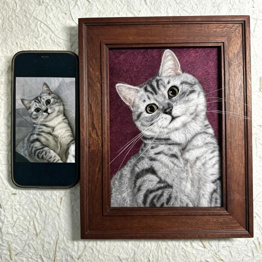 Framed portrait of a cat next to a smartphone displaying a similar image on a textured white background
