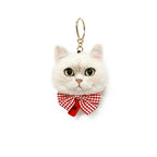 White cat-shaped keychain with a red bow on a white background