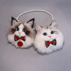 Cat-shaped earrings with plaid bows on a gray background