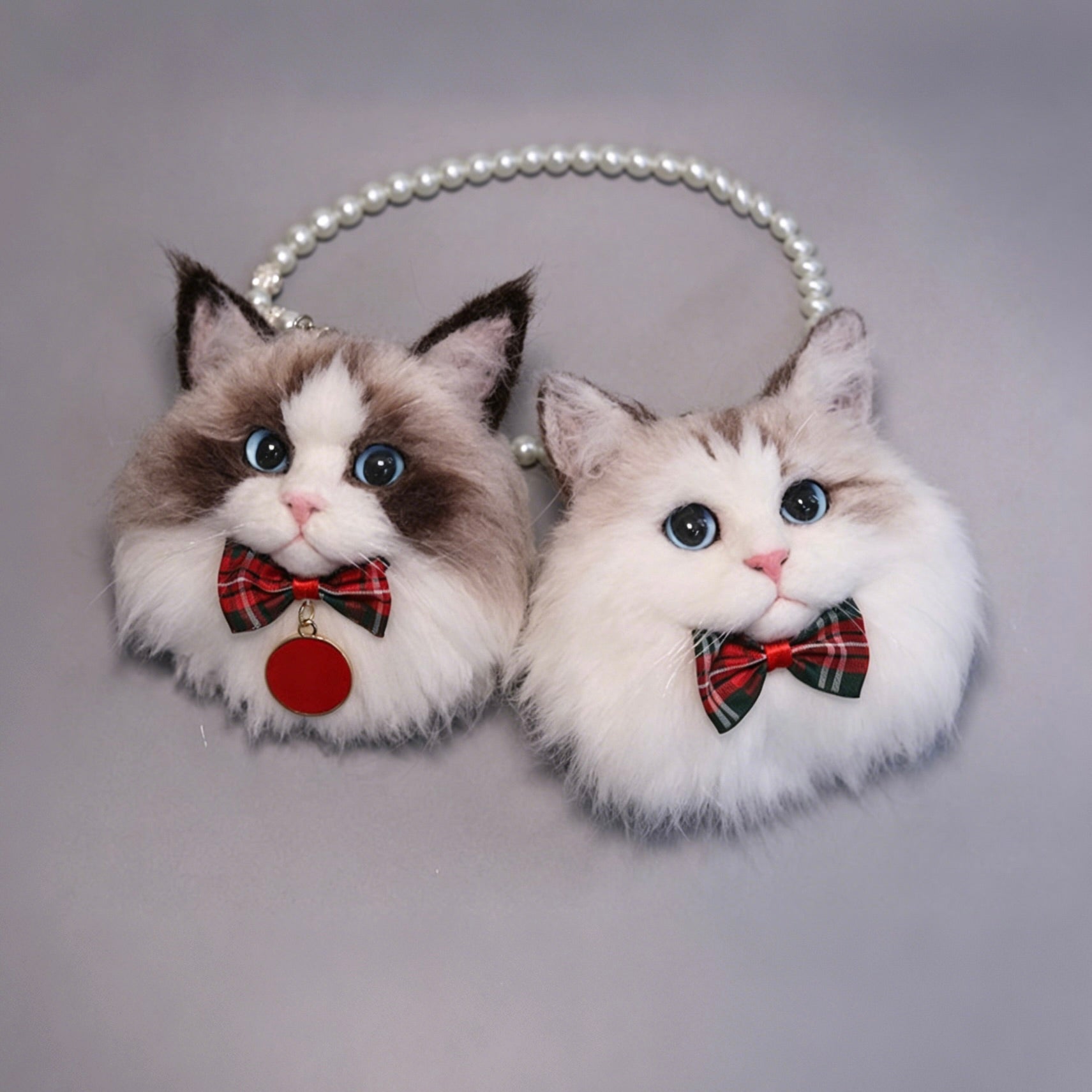 Cat-shaped earrings with plaid bows on a gray background
