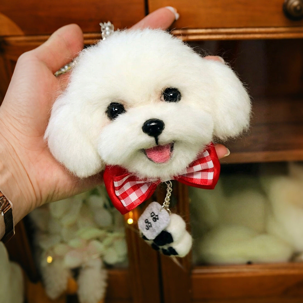 White fluffy dog toy with a red bow held in a hand against a blurred indoor background