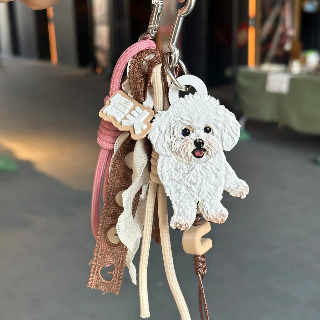 Keychain with a dog charm and decorative elements on a blurred background