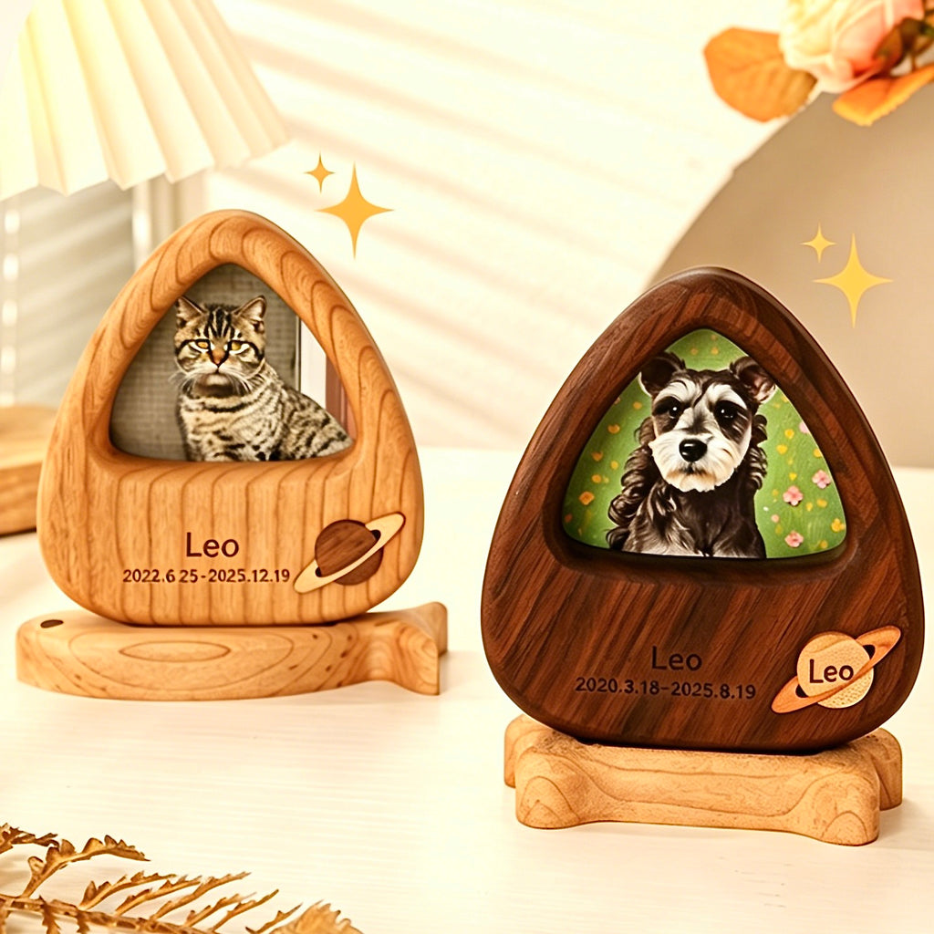 Two wooden pet memorials with engraved names and dates, one featuring a cat and the other a dog.