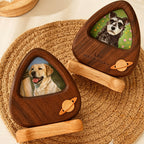 Two wooden pet memorials with engraved names and dates, featuring images of dogs on a woven mat.