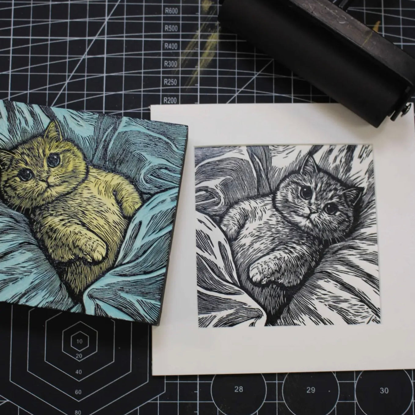 Two cat illustrations on a cutting mat with measurement markings.