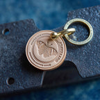 Butterfly-themed keychain with engraved design on a textured surface
