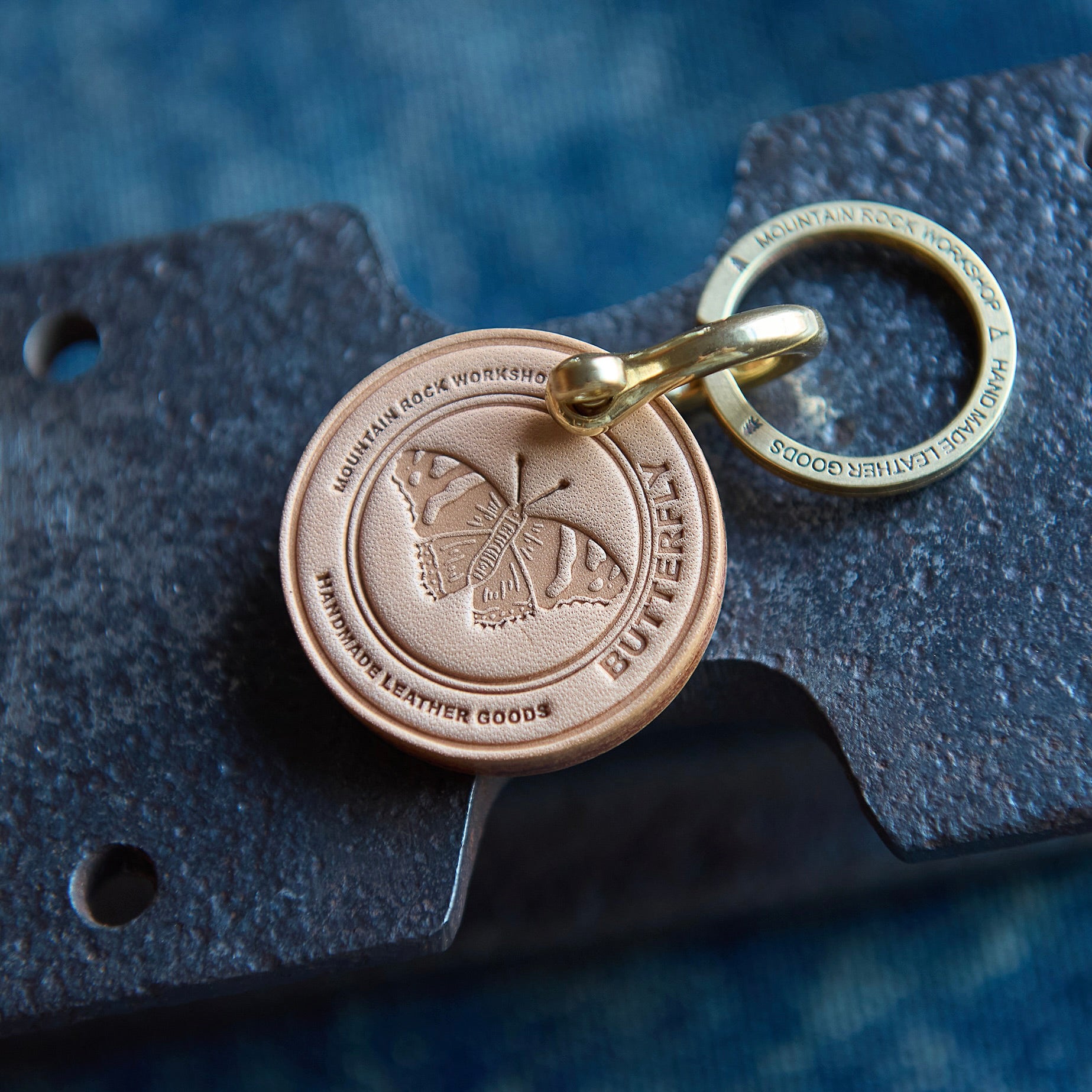 Butterfly-themed keychain with engraved design on a textured surface