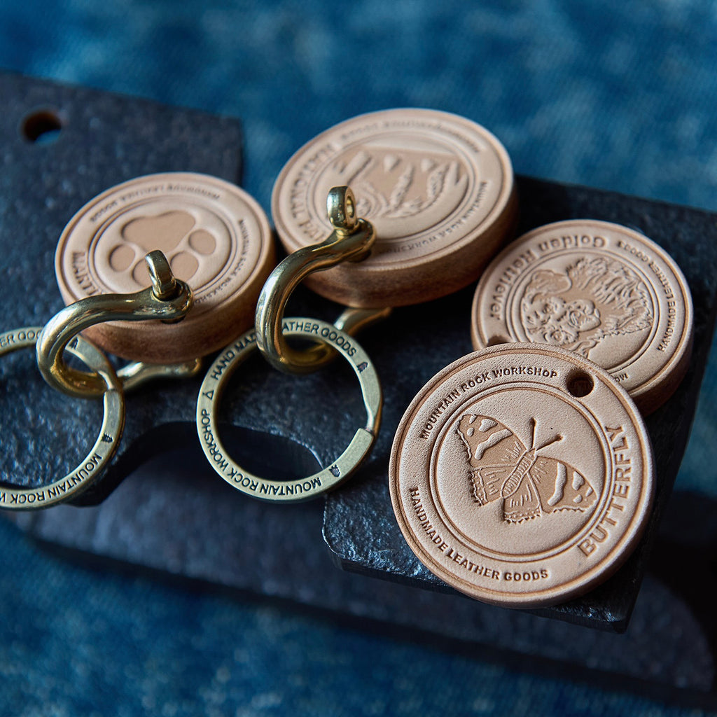 Leather keychains with metal rings on a dark surface