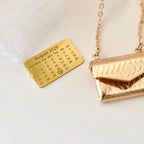 Gold necklace with a calendar pendant on a white background