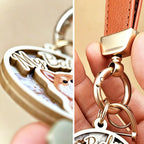 Detailed close-up of a custom 3D wooden pet portrait keychain, showcasing the layered wood relief craftsmanship on the left and the premium gold metal hardware with a brown leather strap on the right.
