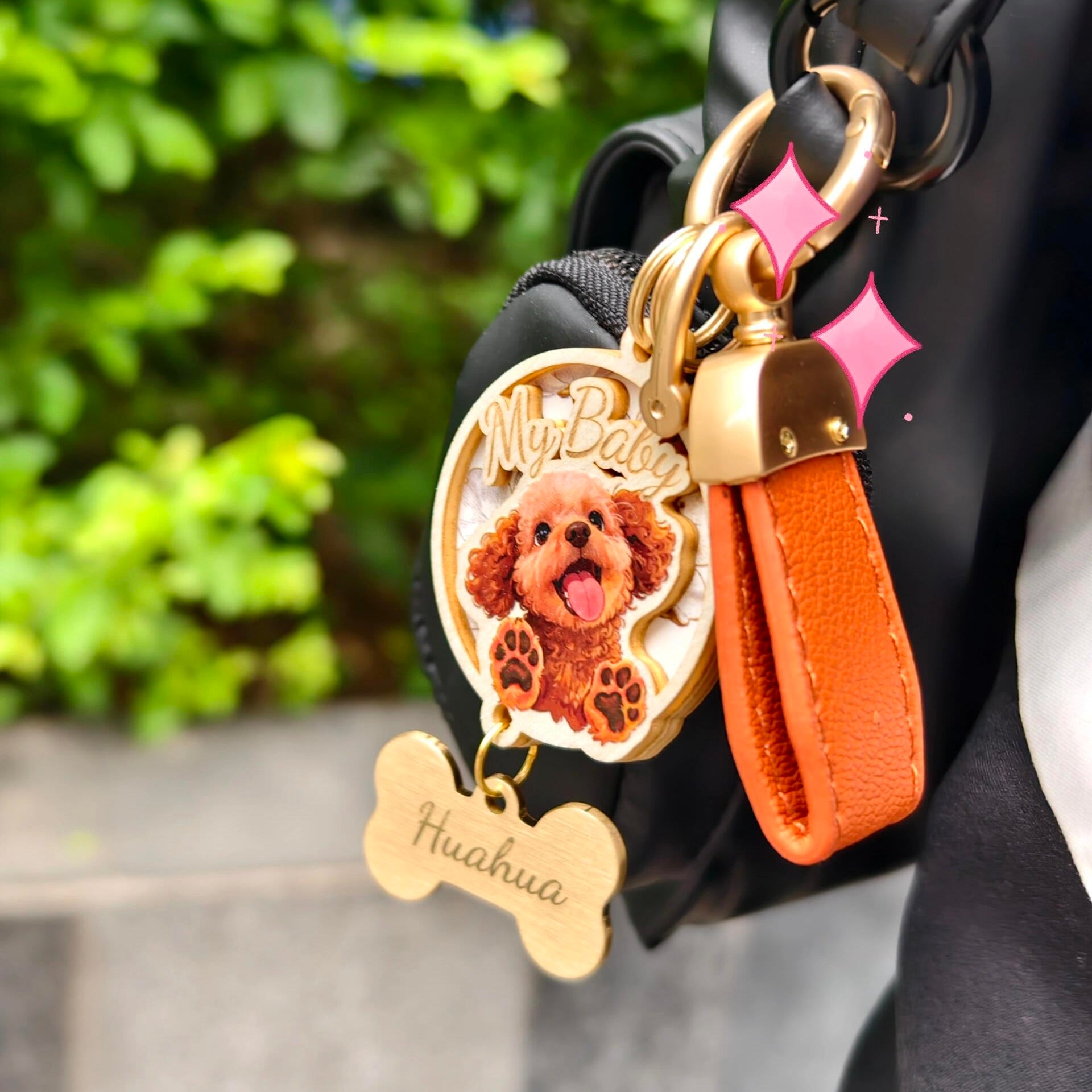 A close-up shot of a custom 3D wooden pet portrait keychain styled as a bag charm, featuring a realistic 3D relief of a brown poodle with the text "My Baby". This personalized memorial keepsake includes a vibrant orange leather strap, gold hardware, and a wooden bone tag engraved with the pet's name "Huahua".
