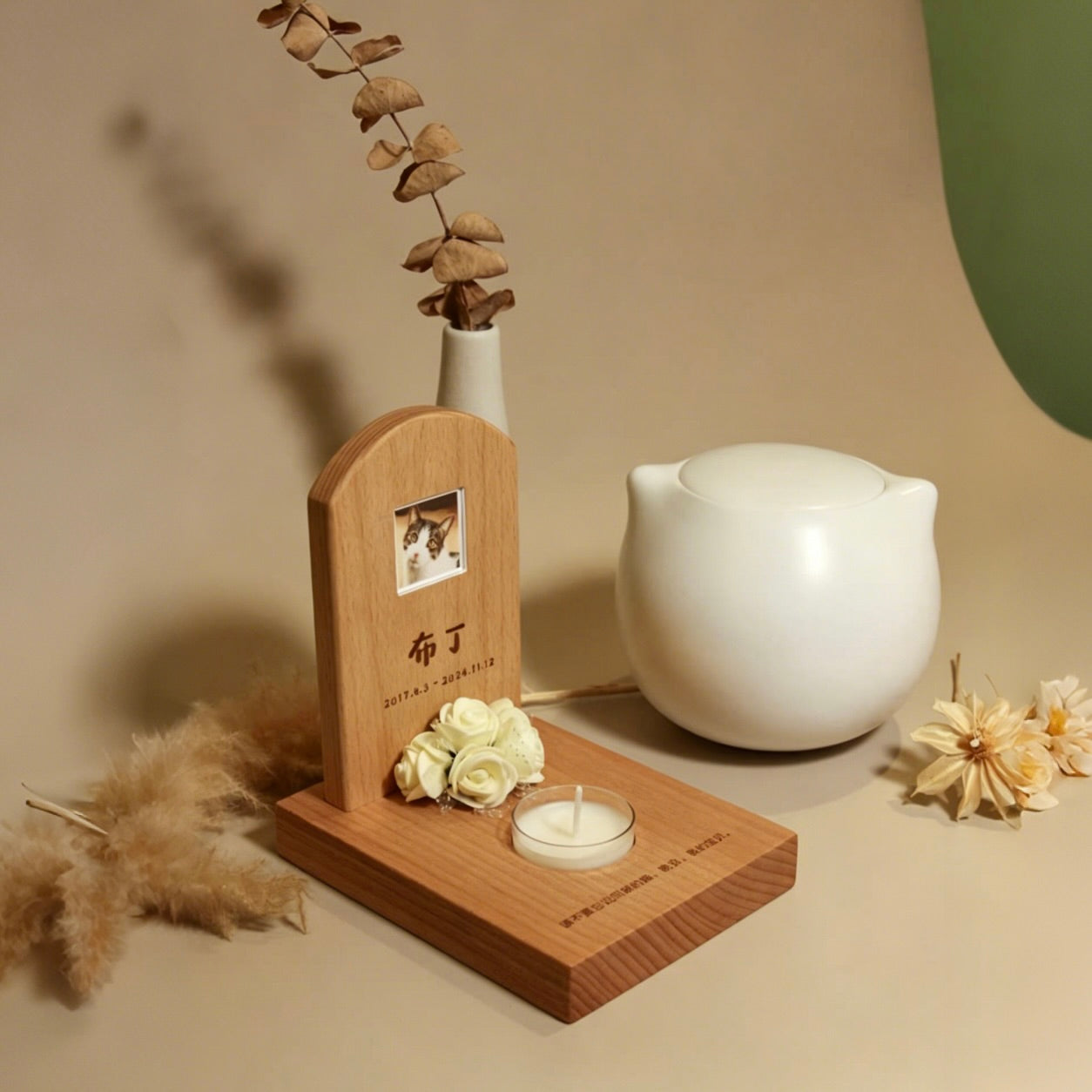 Wooden plaque with a photo of a cat, white flowers, and a white teapot on a beige surface.