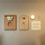 Wooden wall art pieces with floral and photo designs on a beige wall.