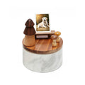 Wooden side table with marble base and decorative items on a white background