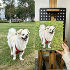 White dog on a leash in a park next to a painting of the same dog.
