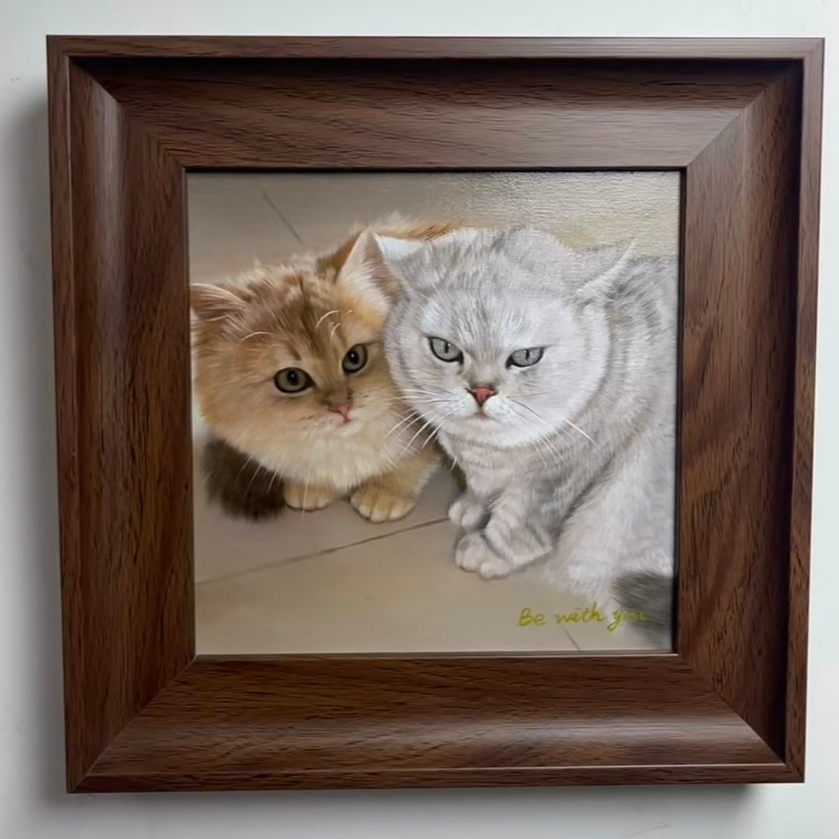 Framed artwork of two cats with a wooden frame.