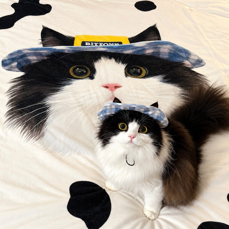 Black and white cat sitting on a custom pet photo sherpa blanket printed with its portrait
