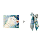 Marble-patterned scarf with a bow next to an illustration of a white cat.