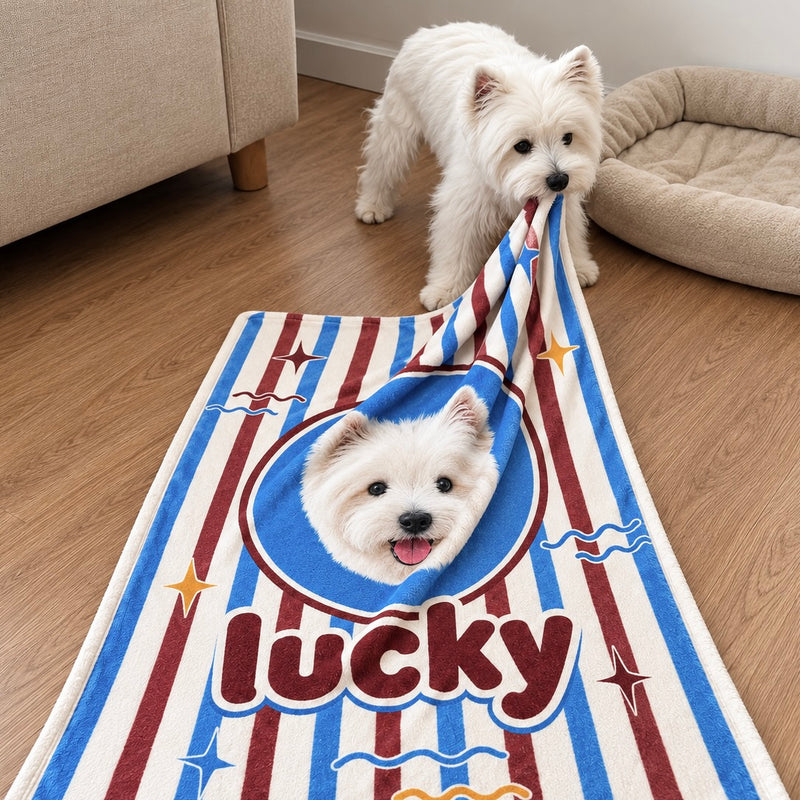 White dog holding a custom pet portrait beach towel featuring its photo and name