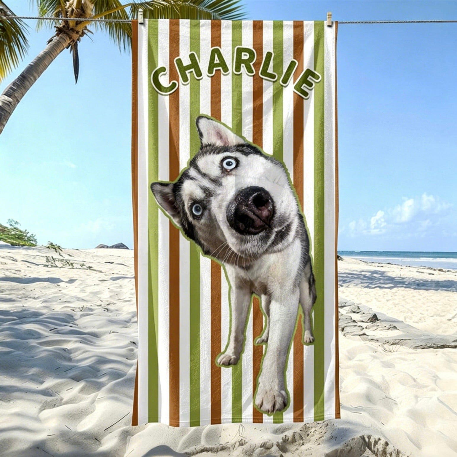 A green and brown striped custom pet portrait beach towel featuring a Siberian Husky and the personalized name Charlie, hanging on a sunny beach.