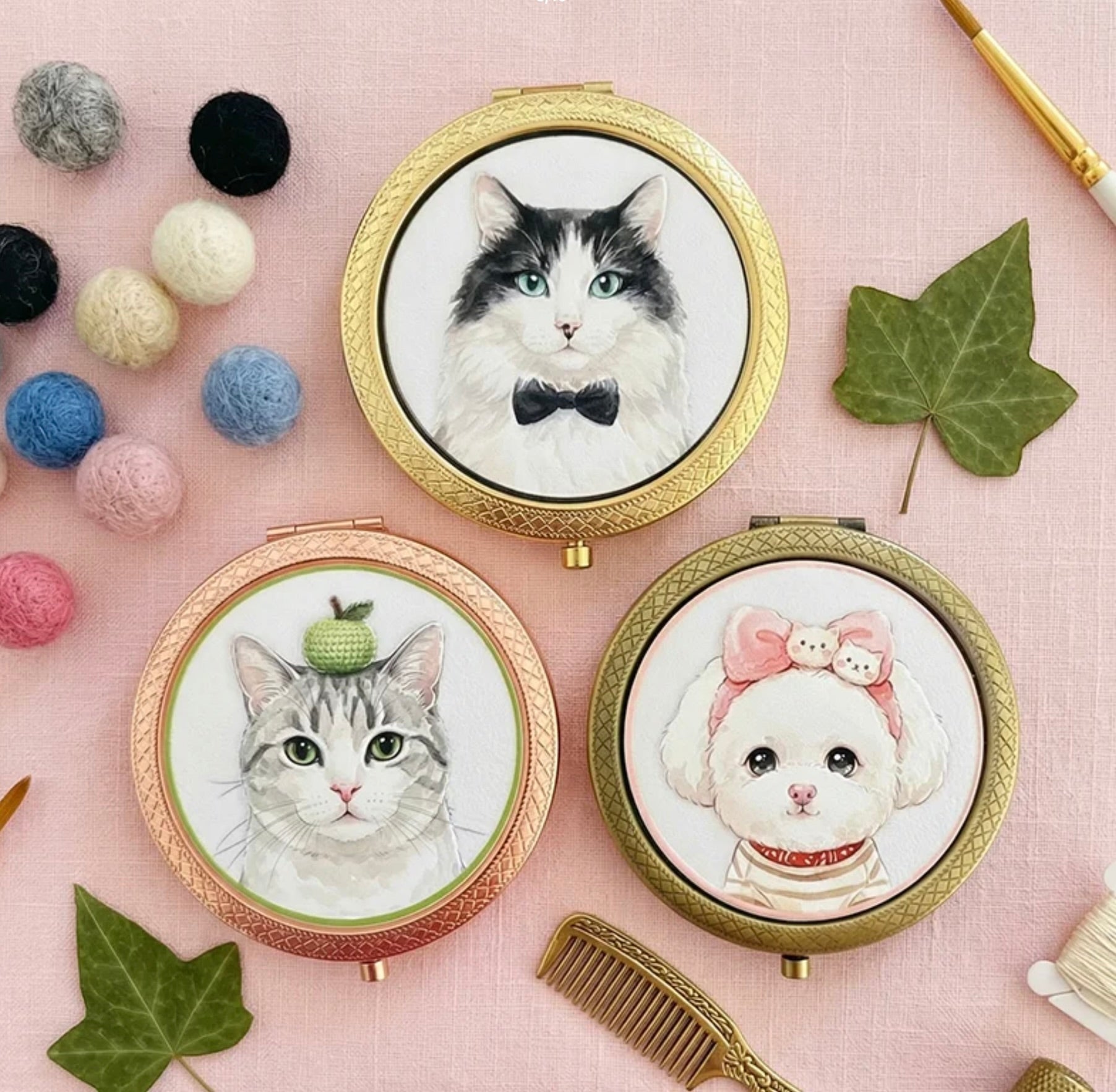 Three compact mirrors with cat and dog illustrations on a pink background with decorative items.