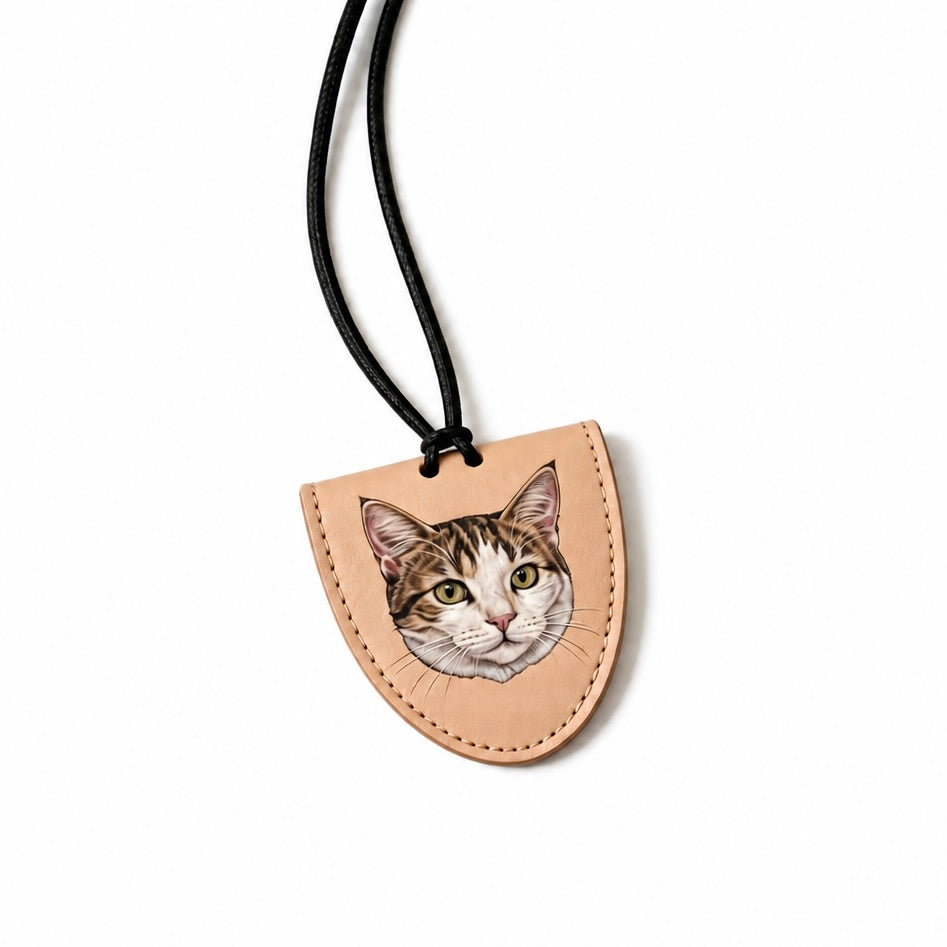 Leather pendant with a cat's face design on a white background