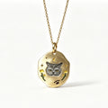 Gold necklace with a pendant featuring a cat's face on a white background