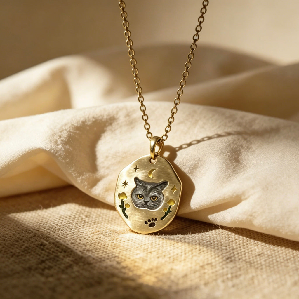 Gold necklace with a pendant featuring a cat design on a beige fabric background