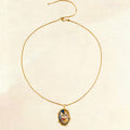 Gold necklace with a pendant on a beige background