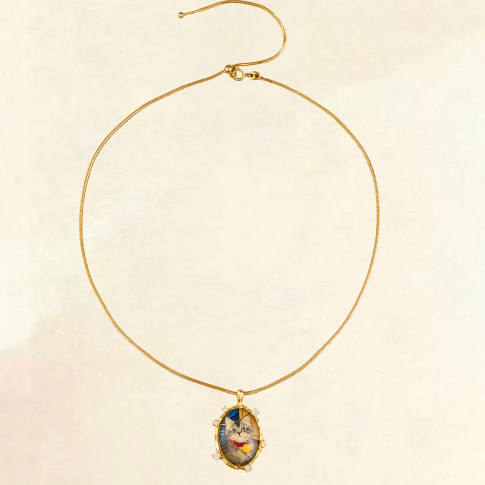 Gold necklace with a pendant on a beige background
