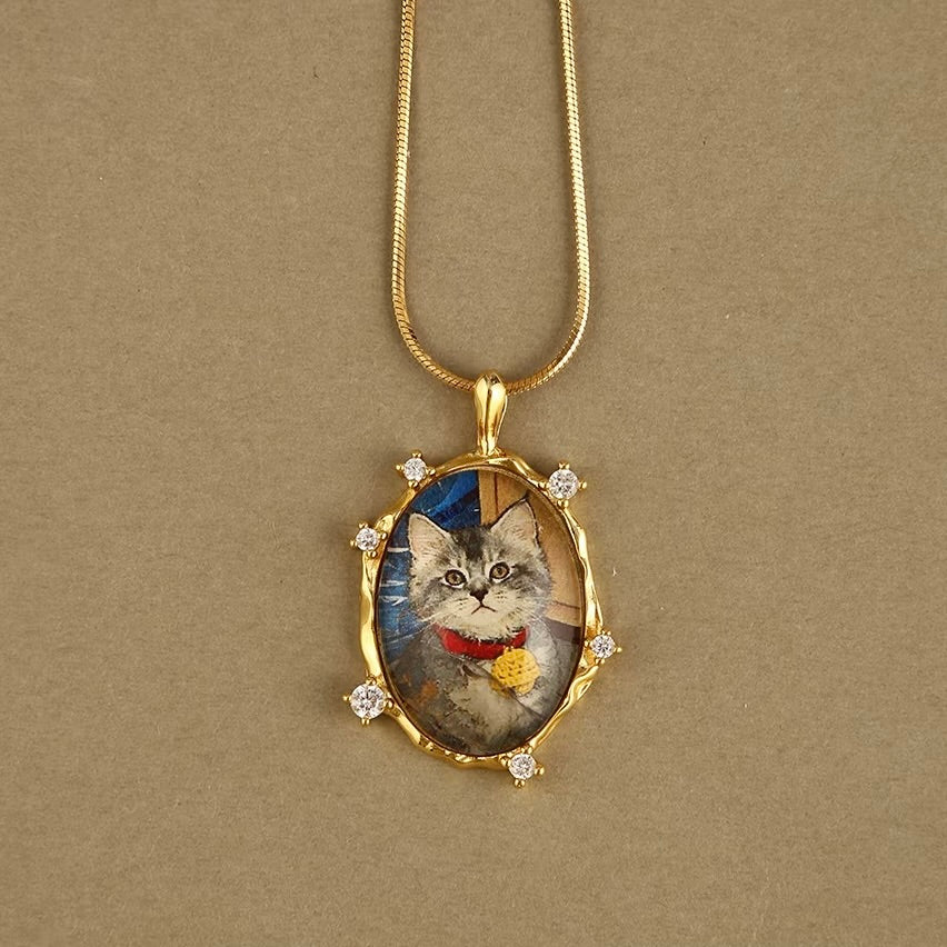 Gold necklace with a pendant featuring a cat's face on a beige background